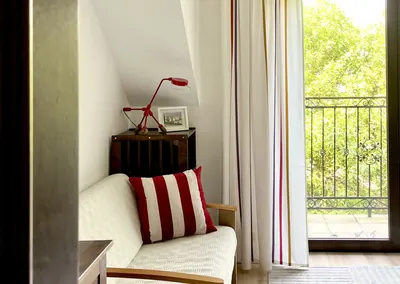 Pokój z wyjściem na balkon, sofą i poduszką w paski